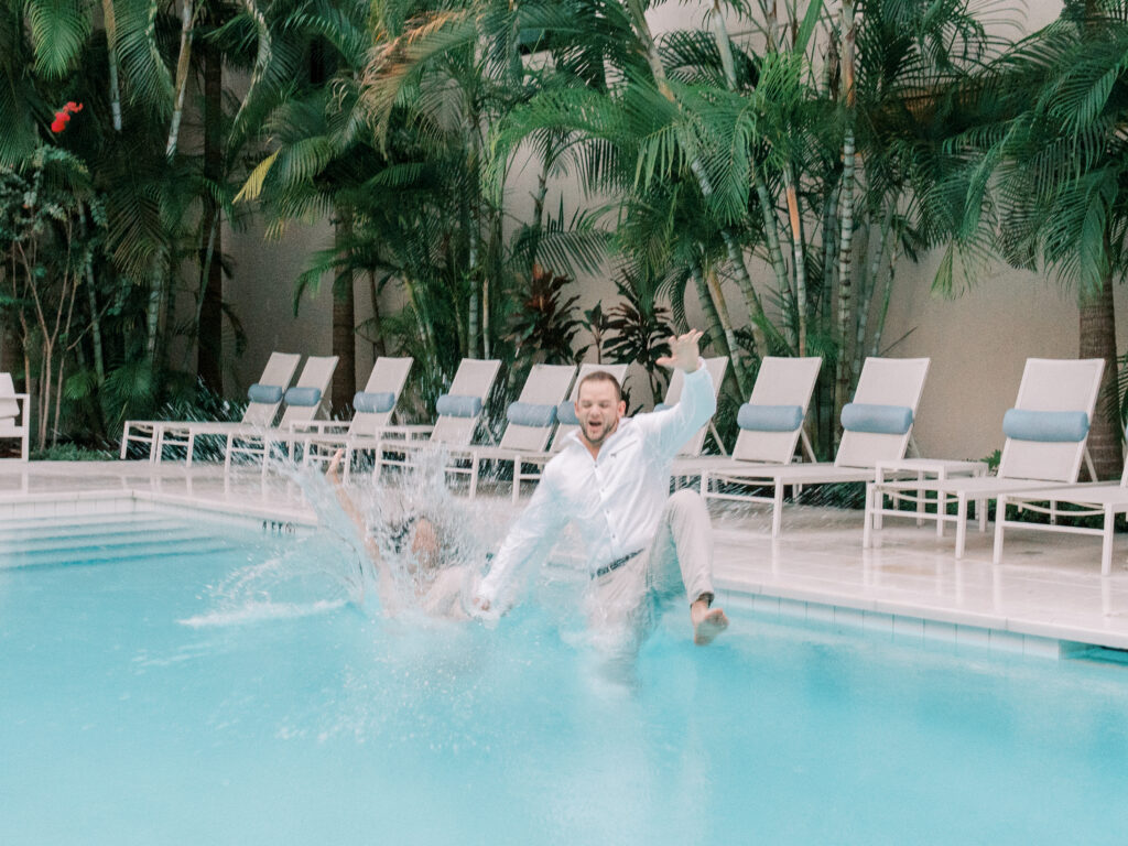 Playful engagement photos with poolside splash in Florida
